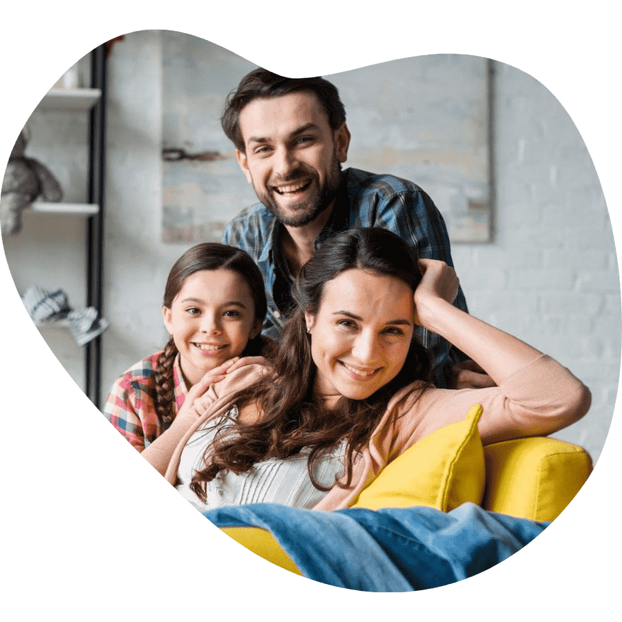 Family photo with mother sitting in yellow chair and husband and daughter standing behind in a cut out shaped like a bean